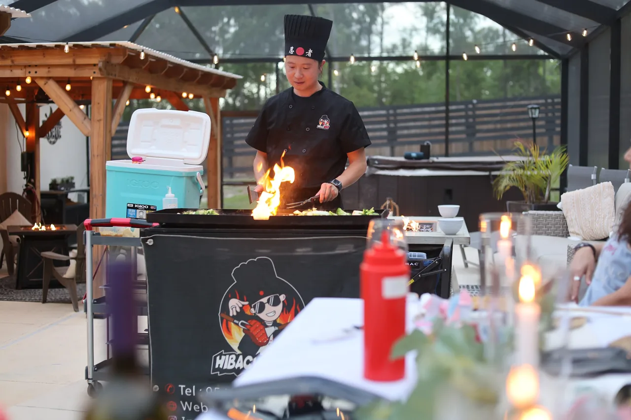A Hibachi Now chef preparing a meal at an outdoor grill